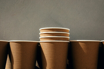 A set of paper utensils, brown cups on a brown background. Eco friendly, zero waste concept. Front view