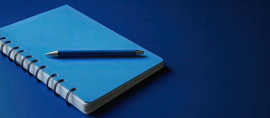 There is a blue tinted image of a notebook and pencil. Copy space image. Place for adding text and design