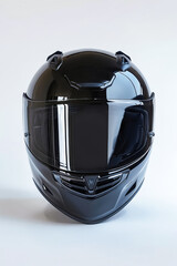A black motorcycle helmet is sitting on a white background. The helmet is shiny and reflective,...