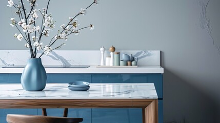 Sleek marble table in minimalist kitchen with blue drawers and decorative items.