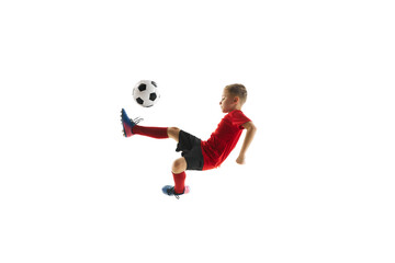 Boy, child, football player in uniform training, kicking ball with knee in mid-air in motion against white studio background. Concept of professional sport, championship, youth league, hobby. Ad