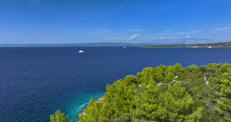 AERIAL: Flying over the pine trees of Korcula reveals the vast Adriatic sea.