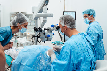 Skilled surgeon and his medical team performs precise eye surgery on an elderly patient, restoring vision with latest medical technology and cutting-edge techniques. Modern eye surgery concept.