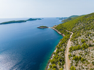 AERIAL: Panoramic view of a coastal road leading to a small peninsula on Korcula