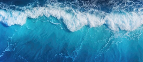 Fototapeta premium Aerial view of the ocean waves with a blue water background providing a natural backdrop Copy space is available for additional elements