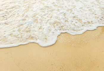 White beach with clear water. Sea waves crashing onto the shore With a yellow sand that looks...