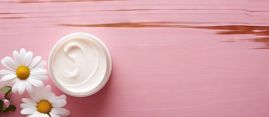 Cosmetic cream featuring a chamomile flower on a pink wooden background an ideal copy space image