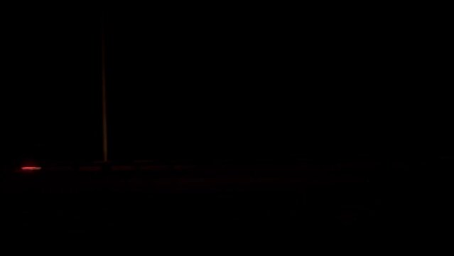 A view of a bridge and moving vehicles at midnight