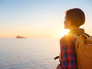 Young woman hiking on rocky beach in Spain, Benidorm