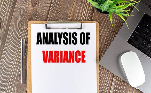 ANALYSIS OF VARIANCE text on clipboard paper with laptop, mouse and pen