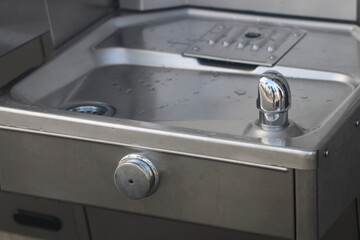 Close-up of a shiny silver sink covered in water droplets
