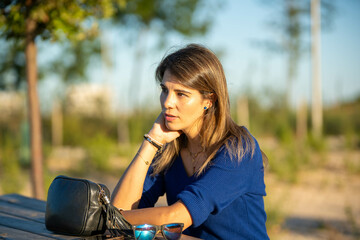 Relaxed woman sitting on a table in the nature.