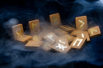 thick Smoke around wooden runes on a dark background close-up	
