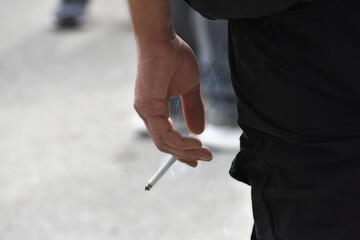 a man stands with a smoking cigarette in his hand