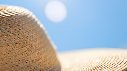 Straw hat lying on the edge of a wheat field, blue sky background