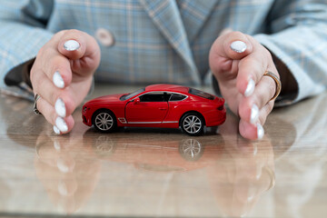 Insurance agent  holding red car toy as vechicle insurance