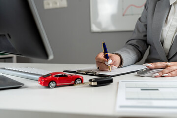 Happy woman signs a contract loan agreement, purchase new car or rent vechicle at office