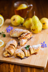 Sweet pastries, puff pastries with pears, on a wooden table
