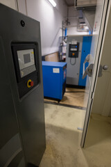 An air compressor control panel in the foreground and another in the background.