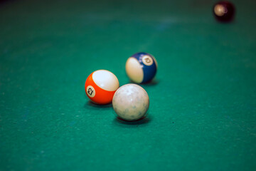 Three multi-colored billiard balls on a green table