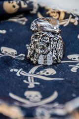 pirate skulls with sabers painted on a dark mat with a ring in the form of a pirate skull 
