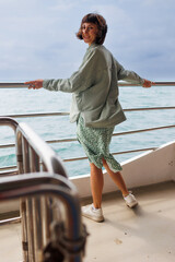 young woman stands on the deck of a cruise ship and enjoys the journey. happy woman. woman on a...