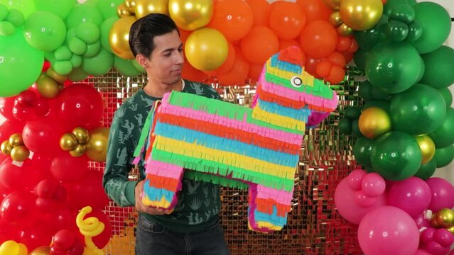 Artist holding self made Mexican donkey pinata for childrens party decoration