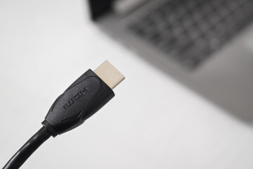 Man is connecting black HDMI cable into HDMI port of the modern laptop on white background