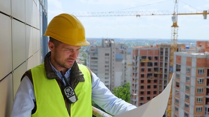 Close up of handsome young professional man engineer working looking at project documentation...