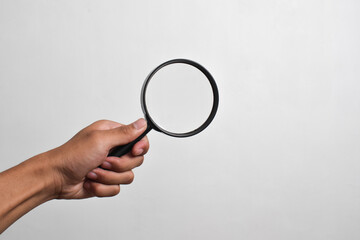 Hand holding Magnifying Glass isolated on white background