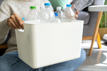 Happy Asian woman keep plastic bottle into trash bins box at home.  Trash Separation concept