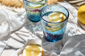 Summer refreshing lemonade drink or non alcoholic cocktail with lemon slices in blue drinking...
