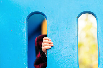 baby hand holding a gate of a playground