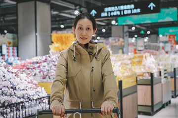 Confident Woman Pushing Cart in Modern Supermarket