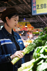 Supermarket Employee Inspecting Fresh Green Vegetables