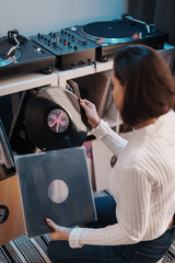 A music lover browsing through vinyl records, adding to her playlist.