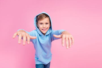 Portrait of carefree positive small boy toothy smile wear hood head arms dance hip hop empty space...