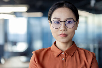 Confident businesswoman in modern office wearing glasses