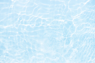 Obraz premium Blue water with ripples on the surface. Defocus blurred transparent blue colored clear calm water surface texture with splashes and bubbles. Water waves with shining pattern texture background.