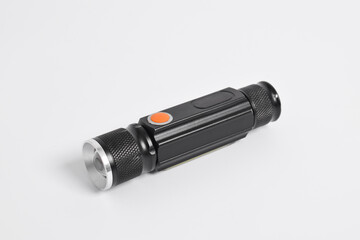 Modern metal LED flashlight in black color isolated on white background. Portable flashlight, LED camping flashlight