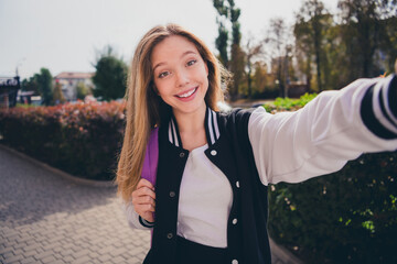 Photo of dreamy cheerful girl wear uniform tacking selfie walking school outside urban city park