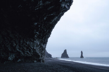 Reynisdrangar dark sea stack at Reynisfjara Beach, Vik, Iceland with moody weather
