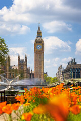 Beautiful summer view of the Big Ben clocktower in London, England, with sunshine and flowers