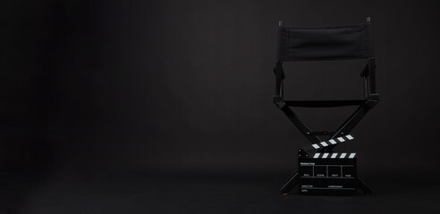 Black director chair and Clapper board on black background.