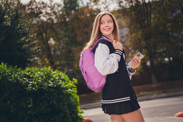 Photo of positive shiny girl wear school uniform mini skirt rucksack chatting instagram twitter...