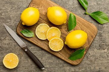 Top view with copy space for fresh and ripe lemons on cutting board. Healthy food background. Elegant background of lemon and lemon slices with squeezer and knife colored background - Powered by Adobe