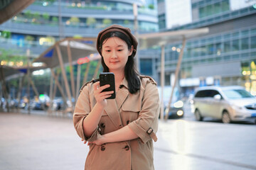Young Woman Engaged with Smartphone in Urban Setting