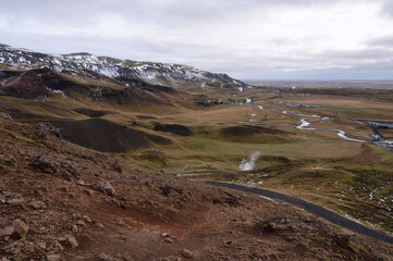Reykjadalur Valley in autumn snow and hot springs, boiling mud pits, Iceland