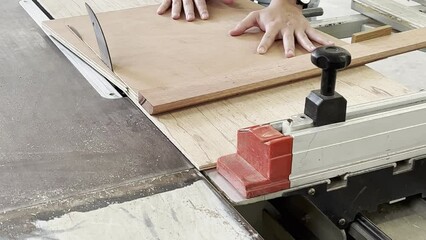 Carpenter cutting plywood on a table saw.