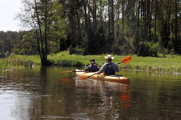 Man and girl in kayak  on  river.
